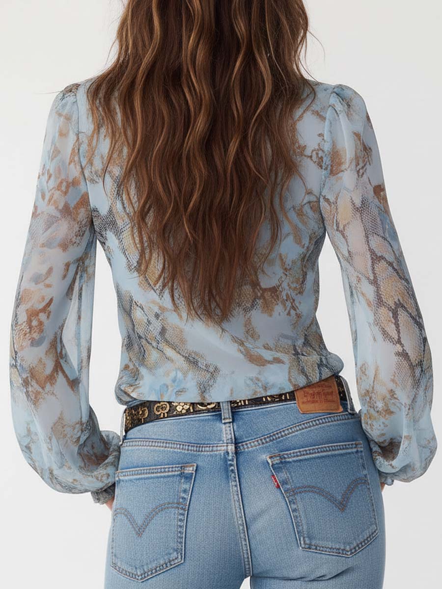 Celeste - Blusa de gasa con volantes y cremallera frontal en un sereno estampado azul.